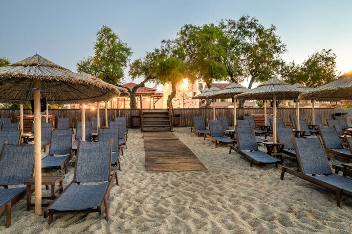 Golden-hour light over straw umbrellas on the bay