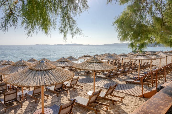 Rows of straw umbrellas with the islands beyond