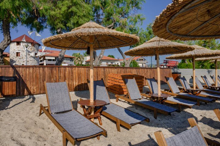Sunbeds on the sand with the windmill behind