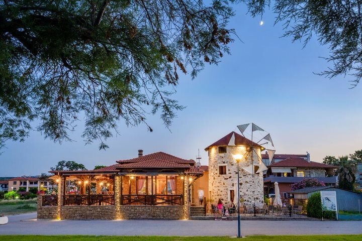 The windmill and adjoining taverna lit at twilight