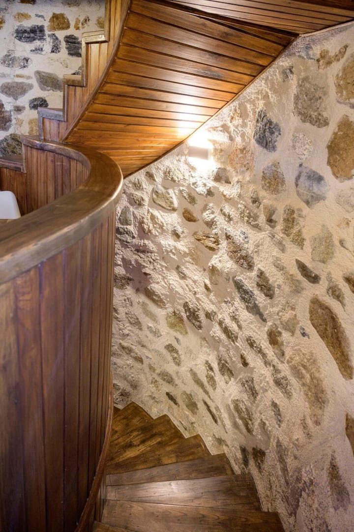 Wooden spiral staircase climbing through the stone tower