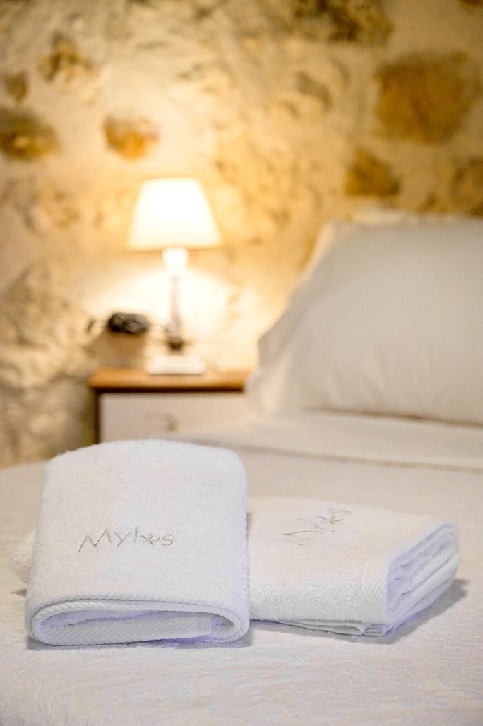 Fresh towels on the bed beside a softly lit lamp
